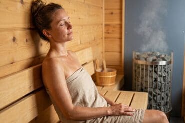 Entspannte Frau in Sauna bei optimaler Thermoregulation.
