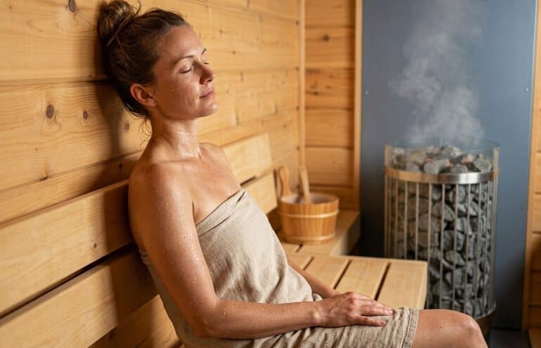 Entspannte Frau in Sauna bei optimaler Thermoregulation.